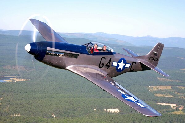 North American fighter P - 51 in the sky over the forests
