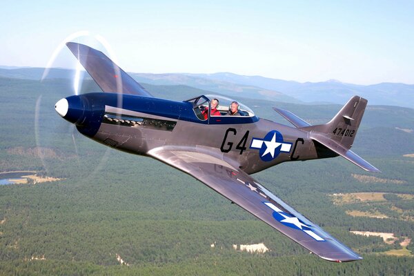 Caza de América del Norte p-51 en el cielo sobre los bosques