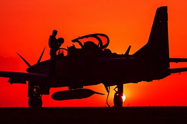 Silhouette of a turboprop attack aircraft on a red background