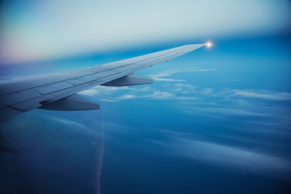 Samolot pasażerski latający pod kątem skrzydła na pięknym tle