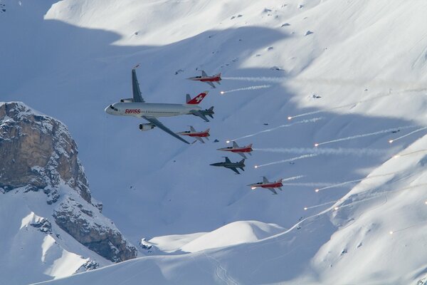 Flugzeuge fliegen vor dem Hintergrund des schneeweißen Schnees