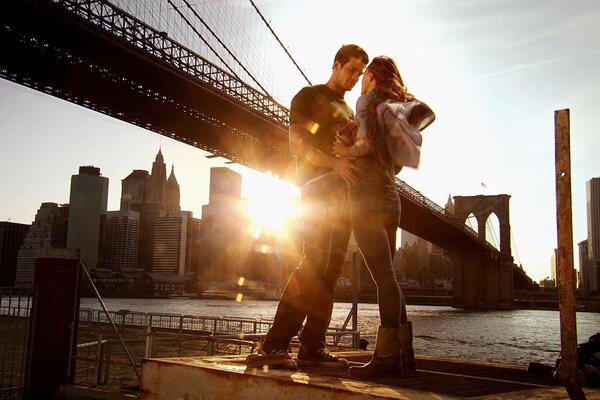 A guy and a girl on the background of a sunset