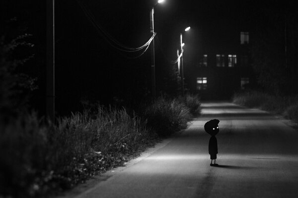 Bambino in una strada buia in mezzo alla città