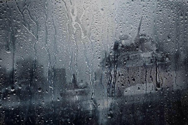 Der Regen läuft tropfenweise über das Glas