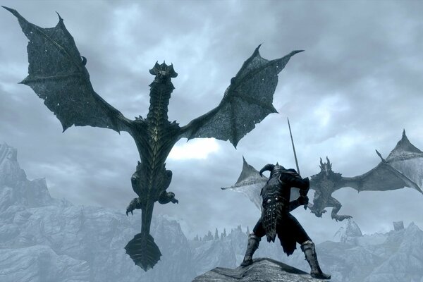 Воин с мечом отбивается от двух драконов на фоне скал