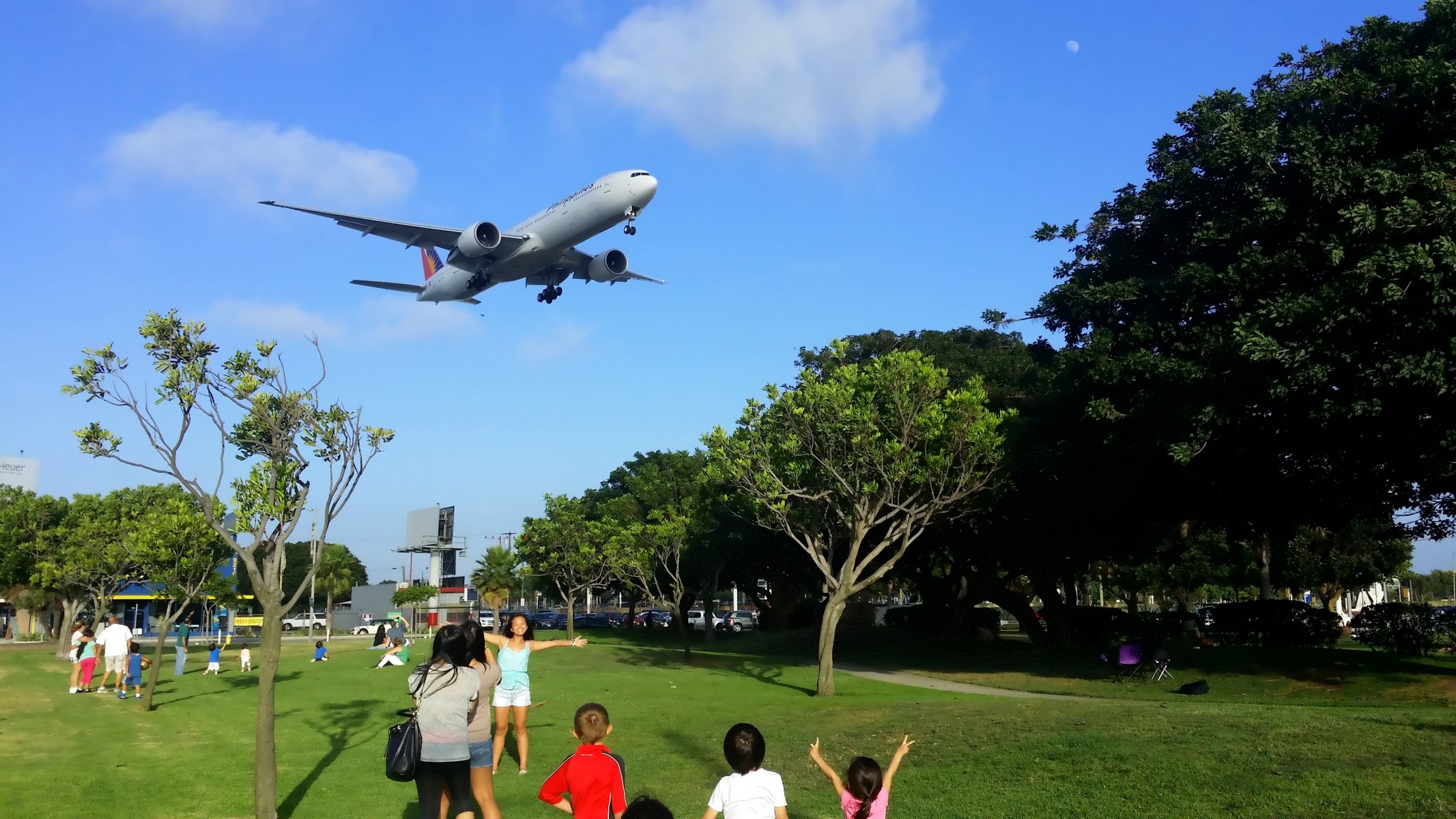 pasajero avión boeing er filipinas líneas aéreas avión aterrizaje tren de aterrizaje cielo nubes personas parque árboles verano pasajero avión hombre verano