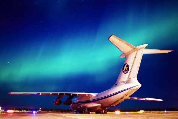 Militär-Transportflugzeug Il-76 nachts am strahlenden Himmel