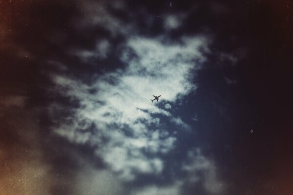 Avión alto en el cielo entre las nubes