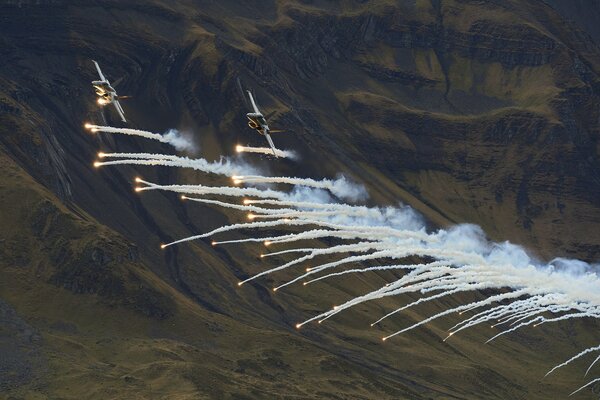 Fighter jets fly across the sky and emit white smoke