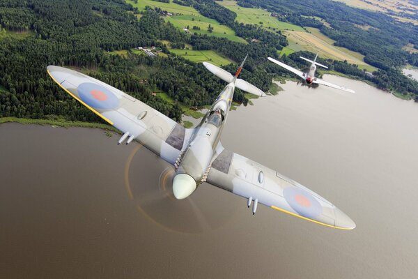 A fighter plane flies over a wide river