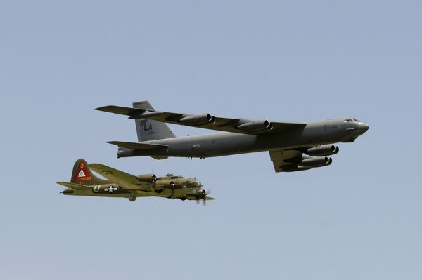 Dos aviones vuelan uno al lado del otro contra un cielo gris