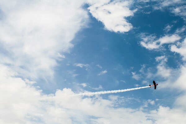 Un aereo di mais vola tra le nuvole e lascia dietro di sé un pennacchio
