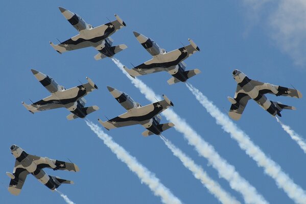Samoloty MiG-17 na pokazach lotniczych lecą na błękitnym niebie