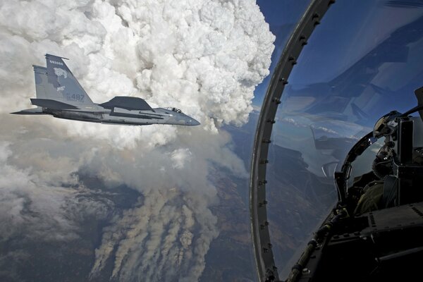 Blick aus dem Cockpit des Piloten auf ein Kampfflugzeug in den Wolken