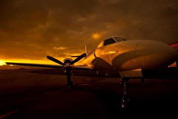 The plane at the airfield at sunset