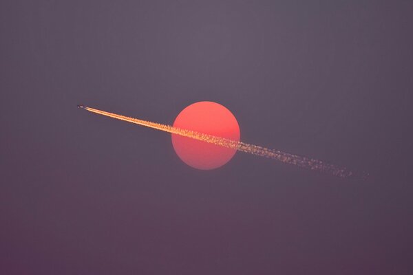 Leaving a trail of an airplane on the background of the sunset sky