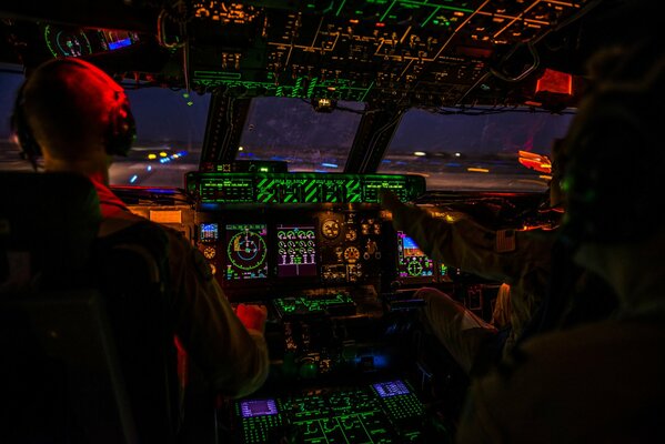 The cockpit of a military transport aircraft, at night