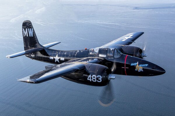 A military fighter flies over the water