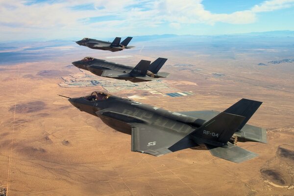 Tres aviones de combate sobre tierra marrón