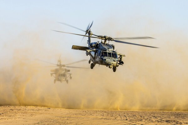 Gli elicotteri nel deserto volano sollevando la polvere