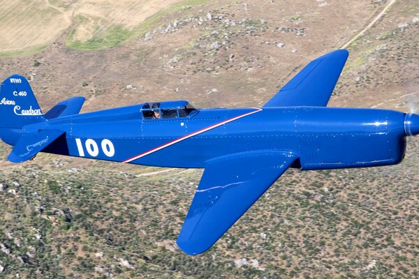 Retro airplane with one pilot flying over the landscape