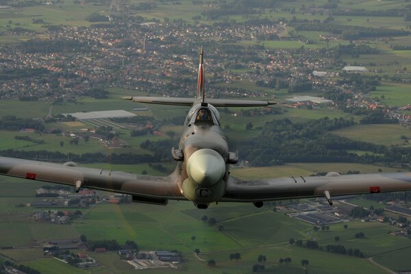 A spitfire fighter over a beautiful landscape