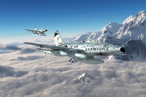 Two American F-100 aircraft fly near the mountains