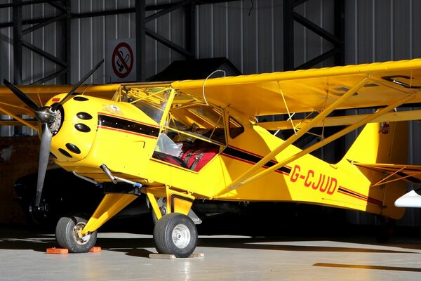 A small plane. Yellow plane. Light aircraft. An American plane. Aircraft with folding wings