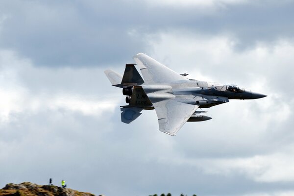 The f15c jet is flying low over the ground