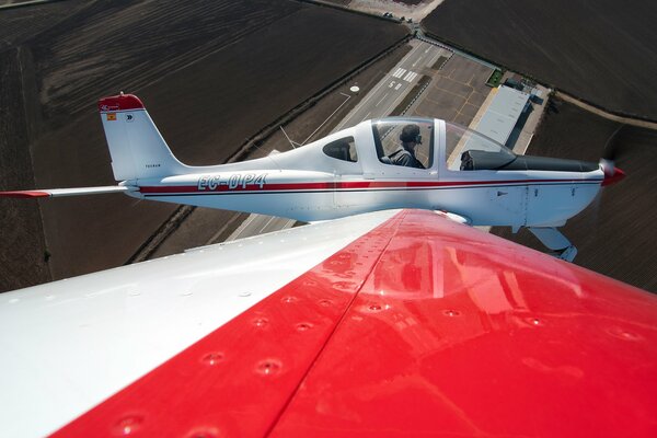 View from the wing of a small white and red plane