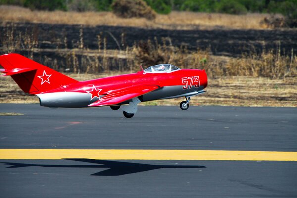 Rotes Flugzeug mit Stern abheben