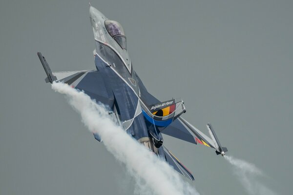 Avión de combate vuela sobre un fondo gris