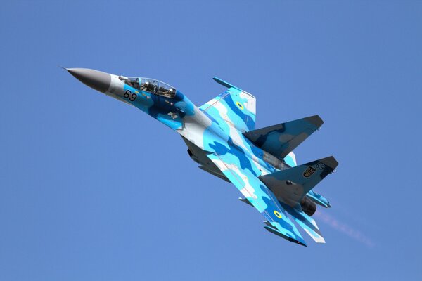 Caza su-27 camuflaje azul, volando en el cielo