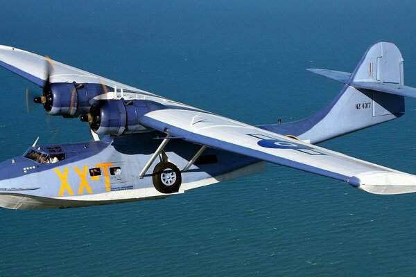 Catalina hydroplane flies against the background of blue water