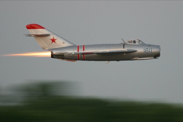 Il MiG-15 grigio sfreccia nel cielo alla velocità della luce
