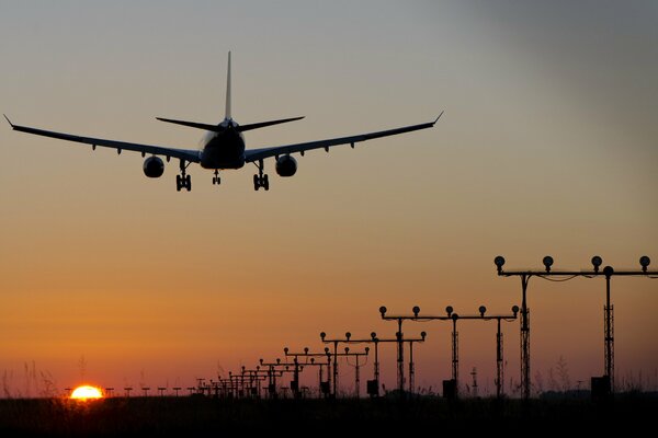 Belle photo de l avion. L avion va atterrir. Avion au coucher du soleil