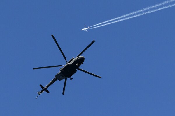 El helicóptero de la fuerza aérea de Rusia Mi-17, y en el fondo vuela Boeing-737