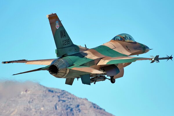 Military fighter F16 flies over the mountains