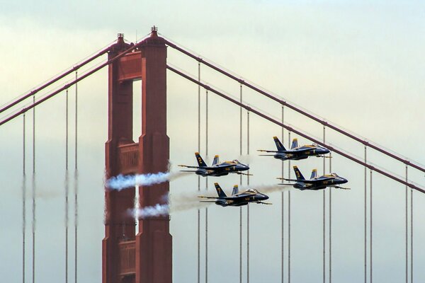 Niebieskie samoloty przelatujące nad wielkim mostem
