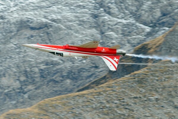 Weiß-rotes Flugzeug auf einem Bergmassiv-Hintergrund