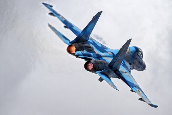 Flight of the multi-purpose blue su-27 fighter rear view