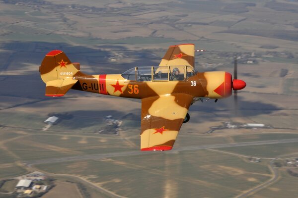 Un avión Yak-52 totalmente metálico en el cielo