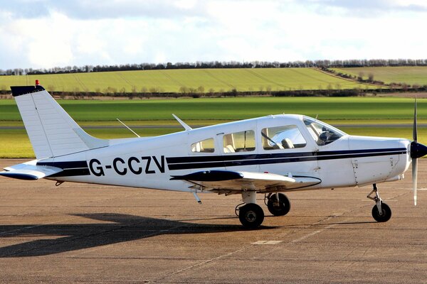 A white plane with two black stripes on the runway