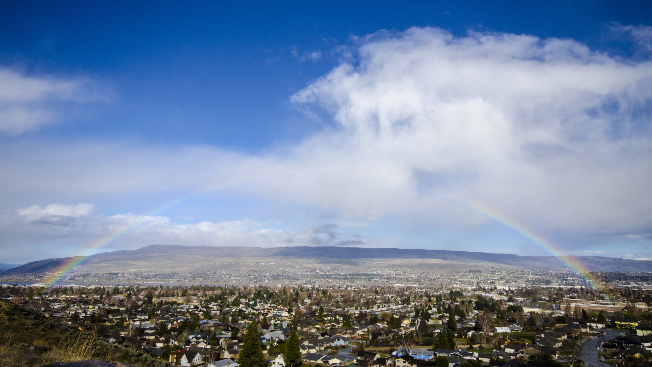 valle colinas casas árboles arco iris cielo nubes