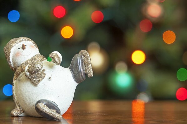 Schneemann Weihnachten Spielzeug auf dem Hintergrund eines geschmückten Weihnachtsbaumes