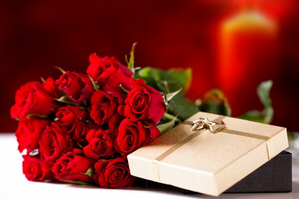 Mazzo di rose rosse accanto al regalo