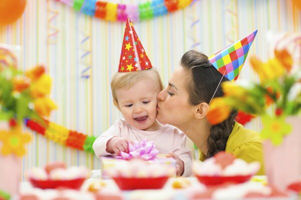 Maman et fils en chapeaux à la table de fête