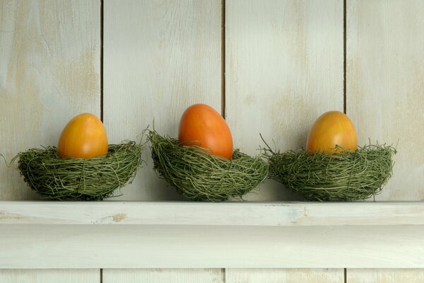 Trzy malowane jajka w zielonych gnojkach