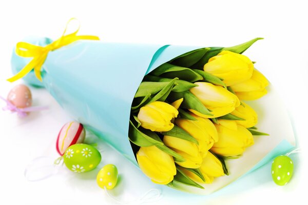 Bouquet of yellow Tulips on the background of Easter eggs