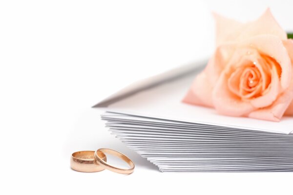 Wallpaper wedding rings and a stack of invitations